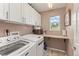 Bright laundry room with white cabinets, countertop, and modern washer and dryer for convenient chores at 16486 W 94Th Dr, Arvada, CO 80007