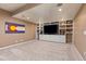 Cozy living room featuring a large entertainment center and neutral carpet throughout the room at 16486 W 94Th Dr, Arvada, CO 80007