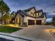 Grand estate exterior features stone accents and a three car garage at 10887 Rainribbon Rd, Highlands Ranch, CO 80126