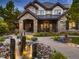 Two-story home with stone exterior and water feature at 10887 Rainribbon Rd, Highlands Ranch, CO 80126