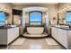 Main bathroom with double vanity, soaking tub, and mountain views at 10887 Rainribbon Rd, Highlands Ranch, CO 80126