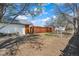 View of the backyard showcasing a wooden fence, side of the house, and mature trees at 45 S Grove St, Denver, CO 80219