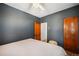 Simple bedroom with blue walls, neutral bedding, hardwood floors, and two traditional wooden doors at 45 S Grove St, Denver, CO 80219