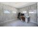 Bedroom with wood-look paneled walls, patterned floor, closet, and desk area with natural light at 45 S Grove St, Denver, CO 80219