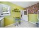 Bright retro kitchen with lime green walls, eat-in counter, colorful wallpaper, and white cabinets at 45 S Grove St, Denver, CO 80219