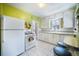 Retro kitchen featuring lime green walls, white appliances and cabinets, and a breakfast nook at 45 S Grove St, Denver, CO 80219