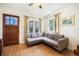 Comfortable living room featuring a modern gray sectional couch, hardwood floors, and a stained glass front door at 45 S Grove St, Denver, CO 80219