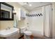 Bathroom featuring white tiled shower over tub, matching toilet and sink at 2000 Little Raven St # 1B, Denver, CO 80202