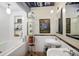 Bathroom with a bathtub, double sink, mosaic floors, exposed ductwork, and glass shelving at 2000 Little Raven St # 1B, Denver, CO 80202