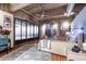 Bedroom featuring exposed ductwork, an accent wall, a blue velvet chair, and a wall of translucent panels at 2000 Little Raven St # 1B, Denver, CO 80202
