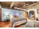 Comfortable bedroom with a concrete ceiling, industrial ductwork, hardwood floors, and a decorative vintage mirror at 2000 Little Raven St # 1B, Denver, CO 80202