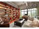 Inviting living room boasts hardwood floors, stylish furniture, and a wall of bookshelves and hanging bicycles at 2000 Little Raven St # 1B, Denver, CO 80202