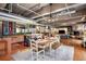 Open living area with dining table, bar seating, hardwood floors, and exposed ductwork at 2000 Little Raven St # 1B, Denver, CO 80202
