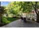 Inviting backyard area with a stone patio, dining set, lush greenery, and privacy fencing at 7746 E Severn Pl, Denver, CO 80230