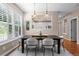Stylish dining room featuring a modern table, pendant lighting, and a view into the adjacent kitchen at 7746 E Severn Pl, Denver, CO 80230