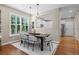 Elegant dining area featuring modern lighting and a seamless connection to the bright, white kitchen at 7746 E Severn Pl, Denver, CO 80230
