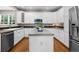 Well-lit kitchen with white cabinets, stainless steel appliances, and a functional center island at 7746 E Severn Pl, Denver, CO 80230