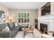 Comfortable living room with a fireplace, plush sofa, and natural light from shuttered windows at 7746 E Severn Pl, Denver, CO 80230