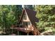 An A-frame home with a deck, perfect for enjoying the surrounding lush greenery at 100 Aspen Ln, Evergreen, CO 80439