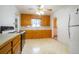 Functional kitchen with wood cabinets, tile flooring, and standard appliances at 3222 Fenton St, Wheat Ridge, CO 80212