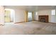 Bright living room featuring a brick fireplace, neutral carpet, and ample natural light at 3222 Fenton St, Wheat Ridge, CO 80212