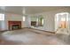 Spacious living room with a brick fireplace, large mirror, and neutral carpet at 3222 Fenton St, Wheat Ridge, CO 80212