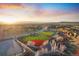 Scenic aerial view of the well-maintained baseball field in a community with an orange sunset in the background at 2320 Morningview Ln, Castle Rock, CO 80109