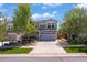 Charming two-story home with a well-manicured lawn, mature trees, and a two-car garage on a sunny day at 2320 Morningview Ln, Castle Rock, CO 80109