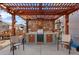 Outdoor patio with a wooden pergola, custom grill station, and cozy seating area at 2320 Morningview Ln, Castle Rock, CO 80109