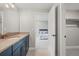 Stylish bathroom featuring modern blue vanity, gold hardware, and open doorway to bedroom at 14341 Beebalm Loop, Parker, CO 80134