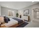 Neutral bedroom with a bed and a dresser with art on the wall and a large window at 14341 Beebalm Loop, Parker, CO 80134