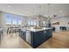 Gourmet kitchen boasts a stainless steel farmhouse sink, expansive island, and seamless transition to the living area at 14341 Beebalm Loop, Parker, CO 80134