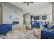Modern living room with fireplace, bright blue furniture, and an open floor plan leading to the kitchen at 14341 Beebalm Loop, Parker, CO 80134