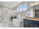 Bright main bathroom featuring a soaking tub, dual sinks, and large vanity with gold accents at 14341 Beebalm Loop, Parker, CO 80134