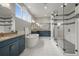 A well-lit primary bathroom features dual vanities, a soaking tub, and a separate glass-enclosed shower at 14341 Beebalm Loop, Parker, CO 80134