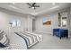 Spacious main bedroom offers a tray ceiling, large windows, and an elegant accent chair at 14341 Beebalm Loop, Parker, CO 80134