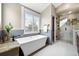 Luxurious bathroom with soaking tub, walk-in shower, stylish tile work, and large shuttered window at 2927 N Humboldt St, Denver, CO 80205