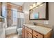 Bathroom featuring tub with shower, granite countertops, and decorative mirror at 2927 N Humboldt St, Denver, CO 80205