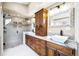 Modern bathroom with dual sinks, granite counters, wood cabinets, walk-in shower, and stylish fixtures at 2927 N Humboldt St, Denver, CO 80205
