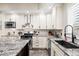 Well-appointed kitchen with stainless appliances, granite counters, white cabinets, and stylish backsplash at 2927 N Humboldt St, Denver, CO 80205