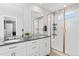 Bright bathroom featuring double sinks, stone countertops, and a modern shower with glass door at 610 Mosquito St, Elizabeth, CO 80107