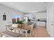Bright kitchen and dining area featuring white cabinets, a center island, and stainless steel appliances at 610 Mosquito St, Elizabeth, CO 80107