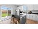 Kitchen island with seating, stainless steel appliances, and a sliding glass door to the backyard at 610 Mosquito St, Elizabeth, CO 80107