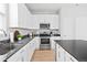 Bright kitchen with white cabinets, stainless steel appliances, dark countertops, and wood-look flooring at 610 Mosquito St, Elizabeth, CO 80107