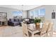 Sunlit living room with a gray sectional couch, dining table and chairs, and large windows at 610 Mosquito St, Elizabeth, CO 80107