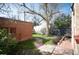 Landscaped backyard with a brick building, stone pathway, brick patio and mature trees at 461 N Marion St, Denver, CO 80218