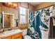 Well-lit bathroom features a shower-tub combo, a window, and a vanity with tiled countertops at 19602 E 63Rd Dr, Aurora, CO 80019