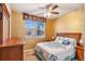 Cozy bedroom features a ceiling fan, a large window, and warm, inviting decor at 19602 E 63Rd Dr, Aurora, CO 80019