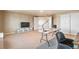 Bonus room with carpet and multiple doorways, featuring a TV and a table for hobbies at 19602 E 63Rd Dr, Aurora, CO 80019