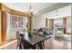 Dining area with a view of the living room showcasing hardwood floors and large windows at 19602 E 63Rd Dr, Aurora, CO 80019